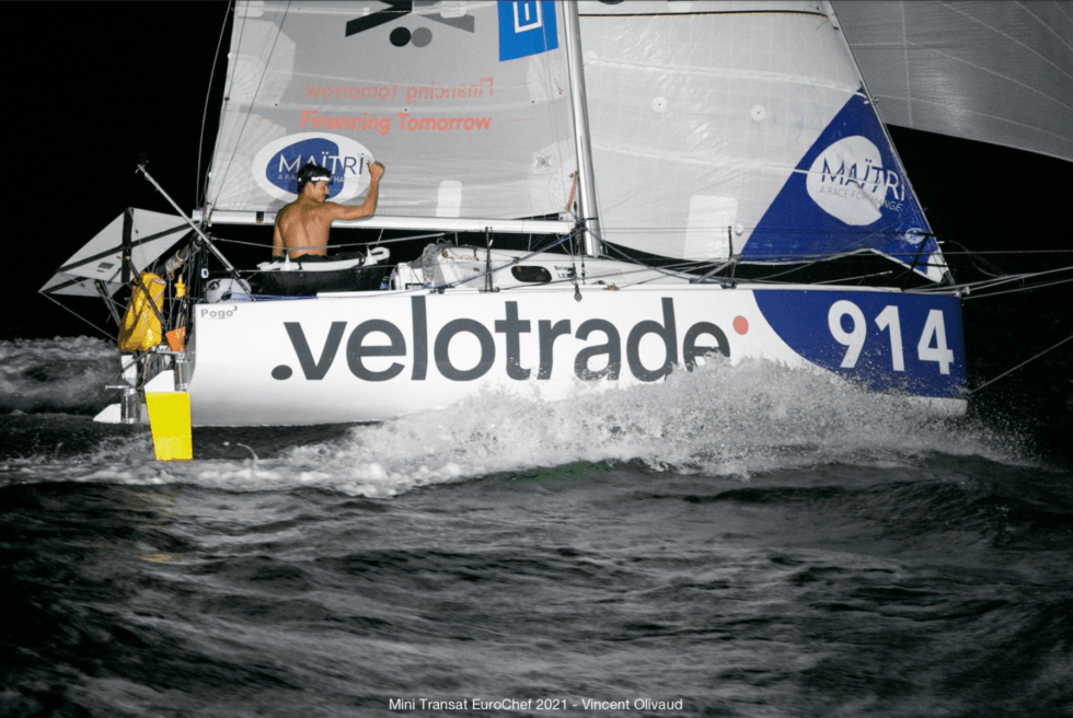 Night shot of the Velotrade sailboat during Mini Transat Leg 2. Full logo and boat number visible.