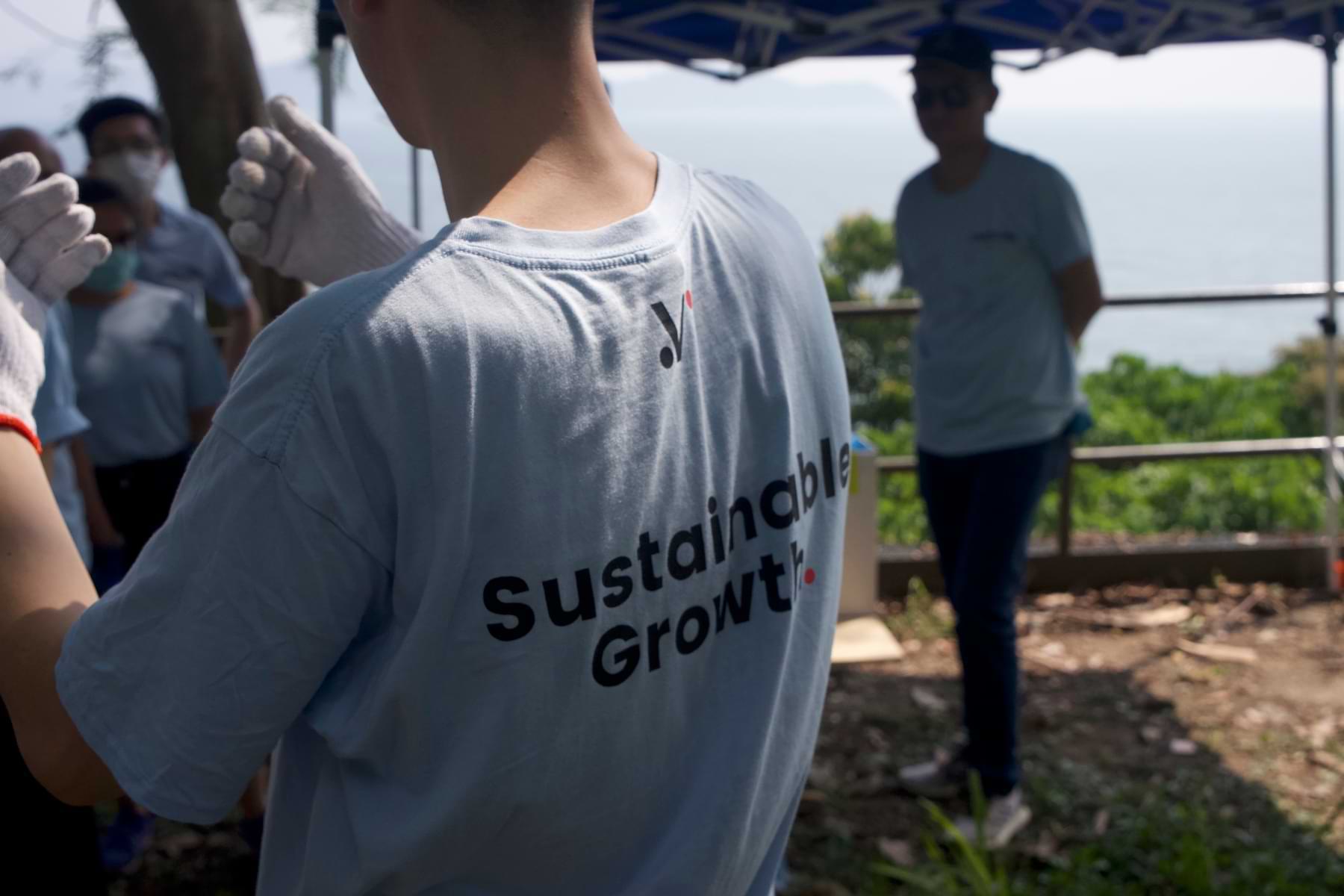 Closeup shot of Velotrade team member wearing a tee with logo and tagline "Sustainable Growth".